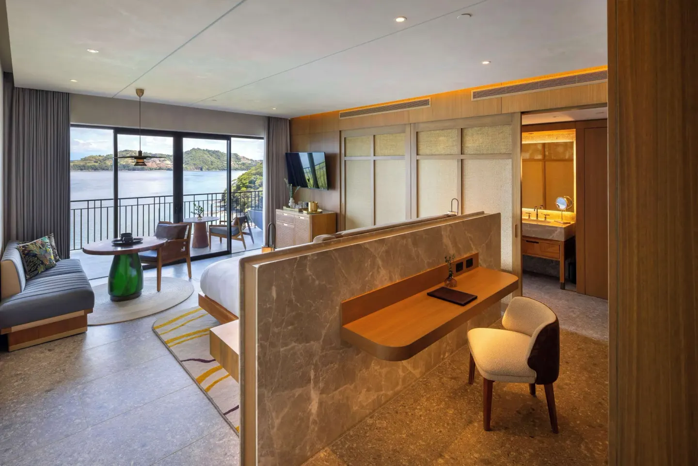 Bedroom, desk, and balcony view in a suite at Waldorf Astoria Costa Rica Punta Cacique.