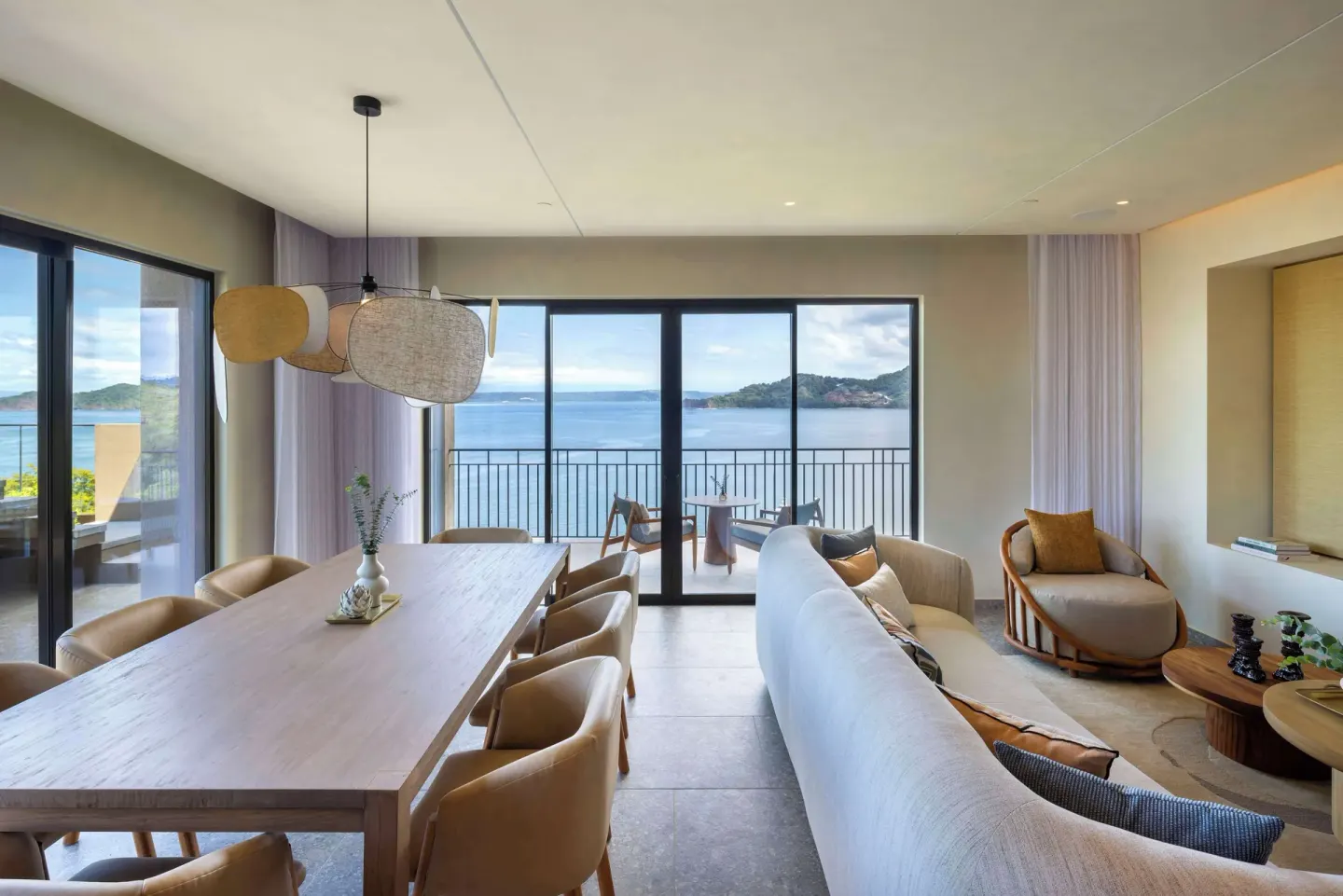 Living and dining area with balcony ocean views at Waldorf Astoria Costa Rica Punta Cacique.
