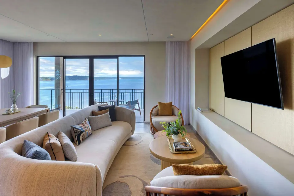Curved sofa and TV in an ocean-view suite at Waldorf Astoria Costa Rica Punta Cacique.