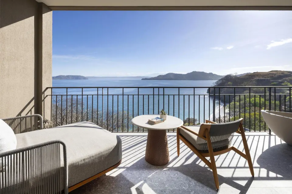 Ocean View 1 Room balcony with chaise, chair, table, and ocean panorama at Waldorf Astoria Costa Rica Punta Cacique.