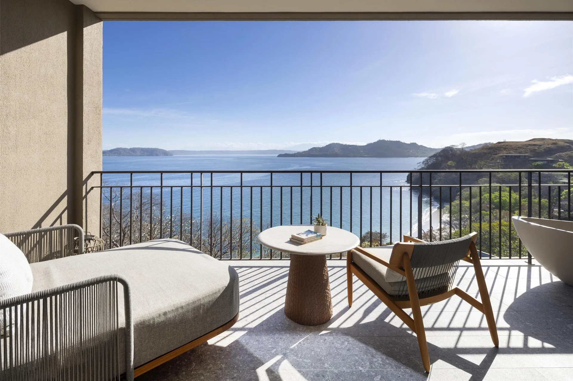 Ocean View 1 Room balcony with chaise, chair, table, and ocean panorama at Waldorf Astoria Costa Rica Punta Cacique.
