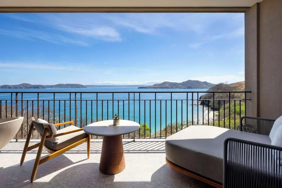 Ocean View 1 Room balcony with lounge seating and bay view at Waldorf Astoria Costa Rica Punta Cacique.