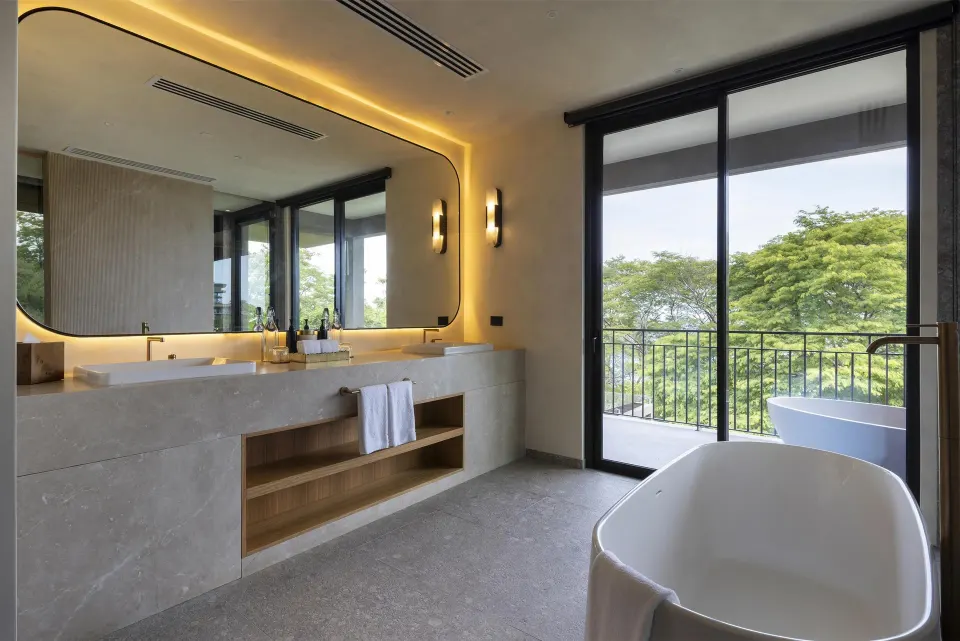Villa bathroom with soaking tub and balcony greenery at Waldorf Astoria Costa Rica Punta Cacique.