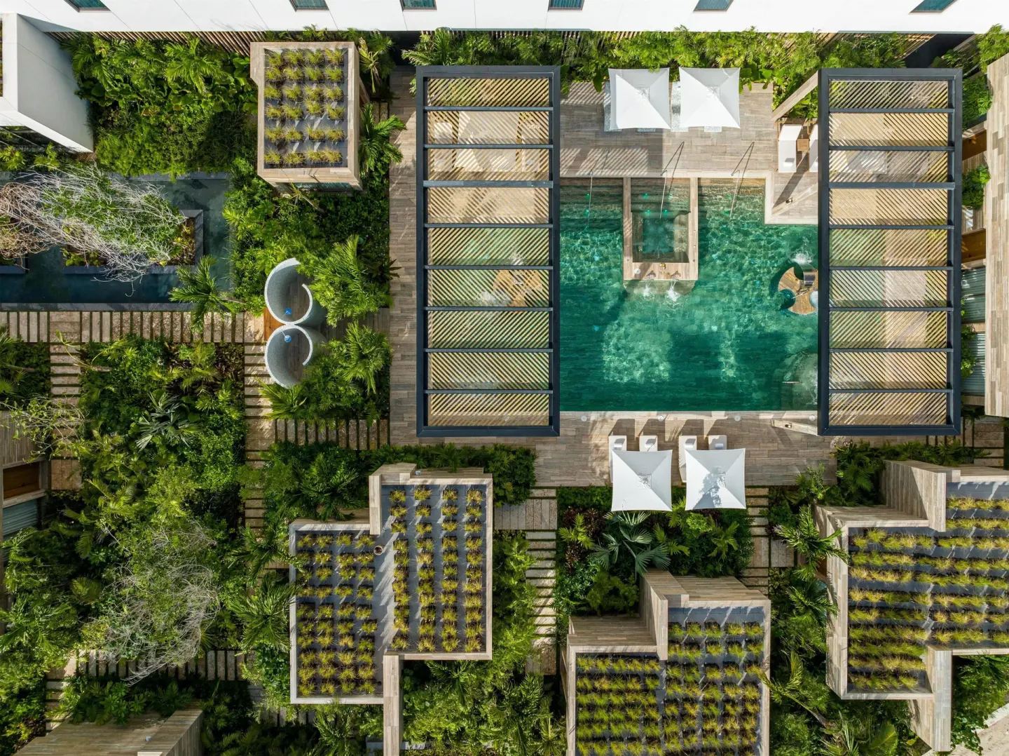 Aerial view of a garden-framed pool courtyard at Waldorf Astoria Riviera Maya.