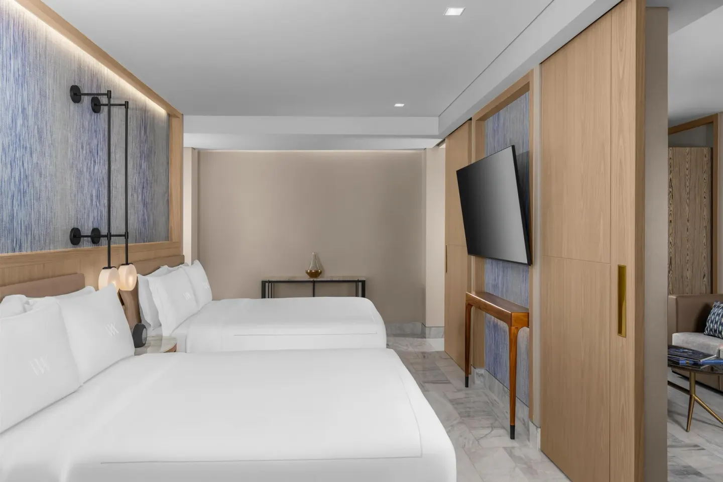 Two queen beds and wall-mounted TV in a guest room at Waldorf Astoria Riviera Maya.