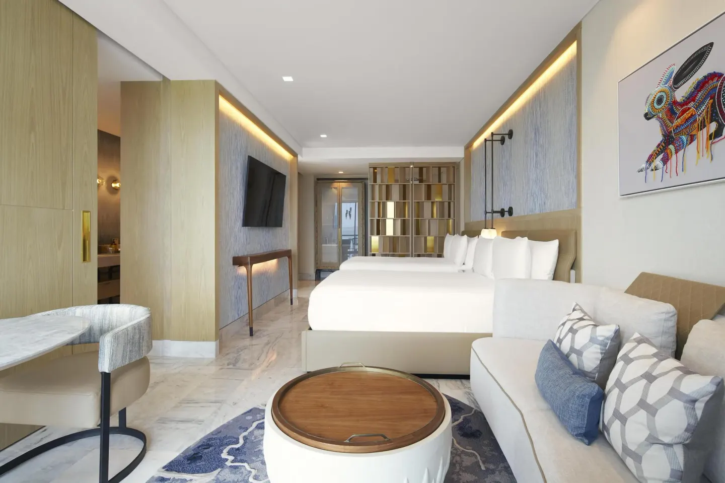 Guest room with two queen beds and sofa at Waldorf Astoria Riviera Maya.