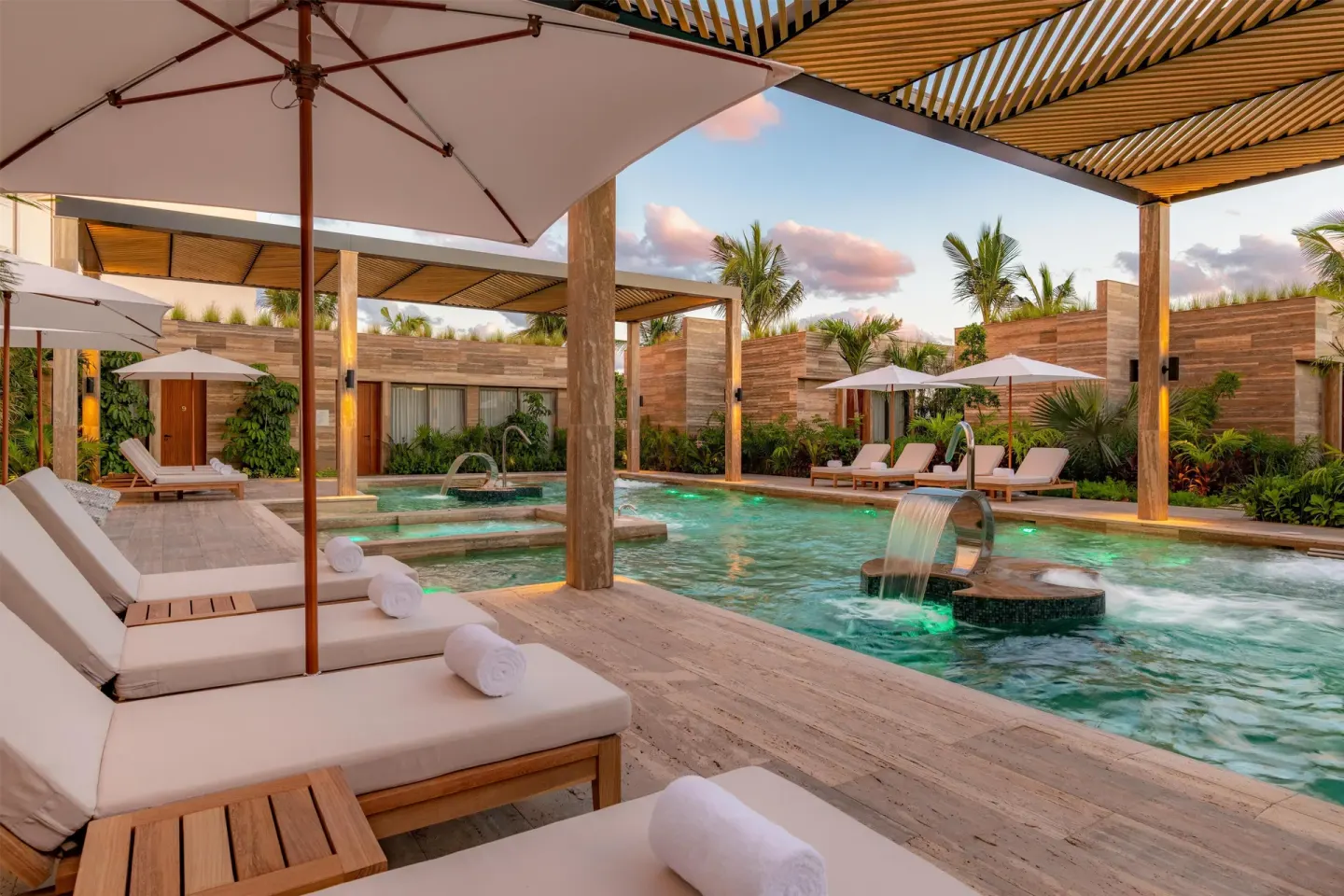 Hydrotherapy pool with loungers and umbrellas at Waldorf Astoria Riviera Maya.
