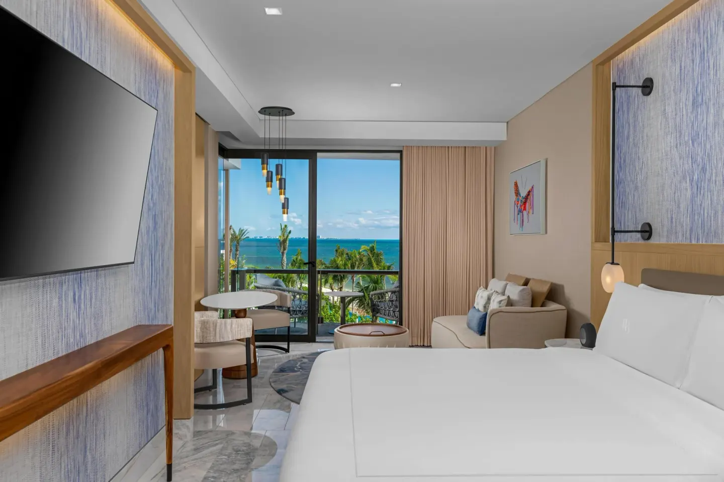 King bed guest room with balcony and turquoise water view at Waldorf Astoria Riviera Maya.