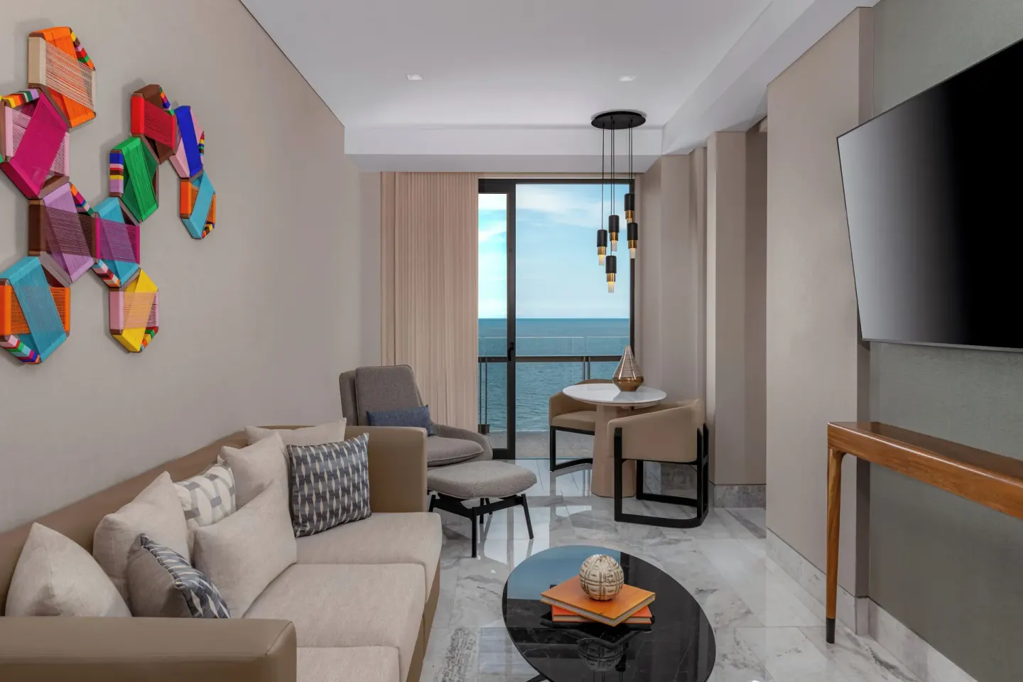 Ocean-view sitting area with sofa and balcony at Waldorf Astoria Riviera Maya.