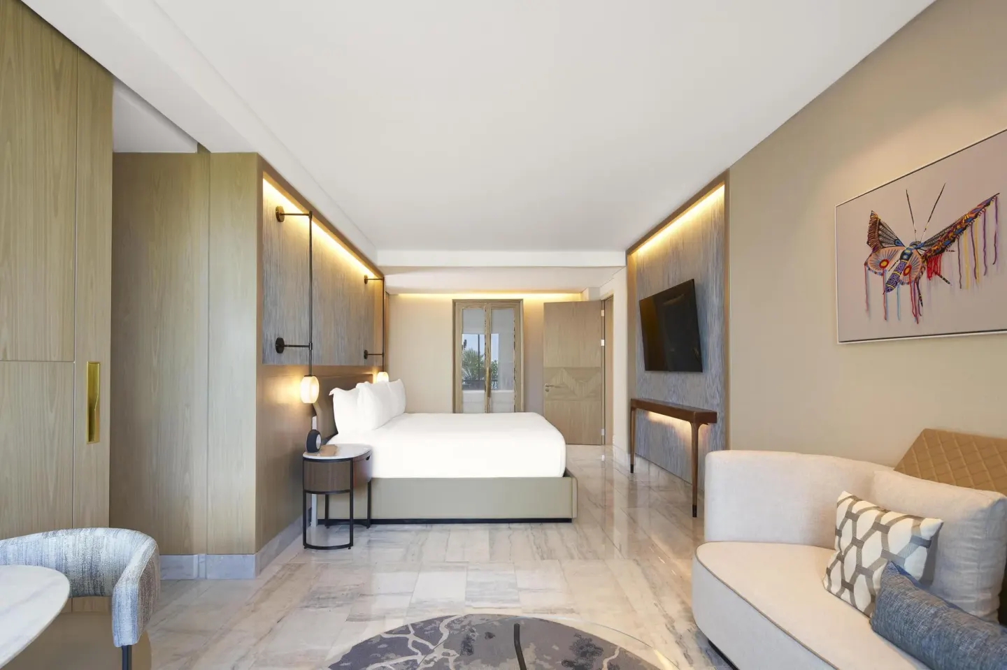 Spacious king bed suite with sofa seating and wall art at Waldorf Astoria Riviera Maya.