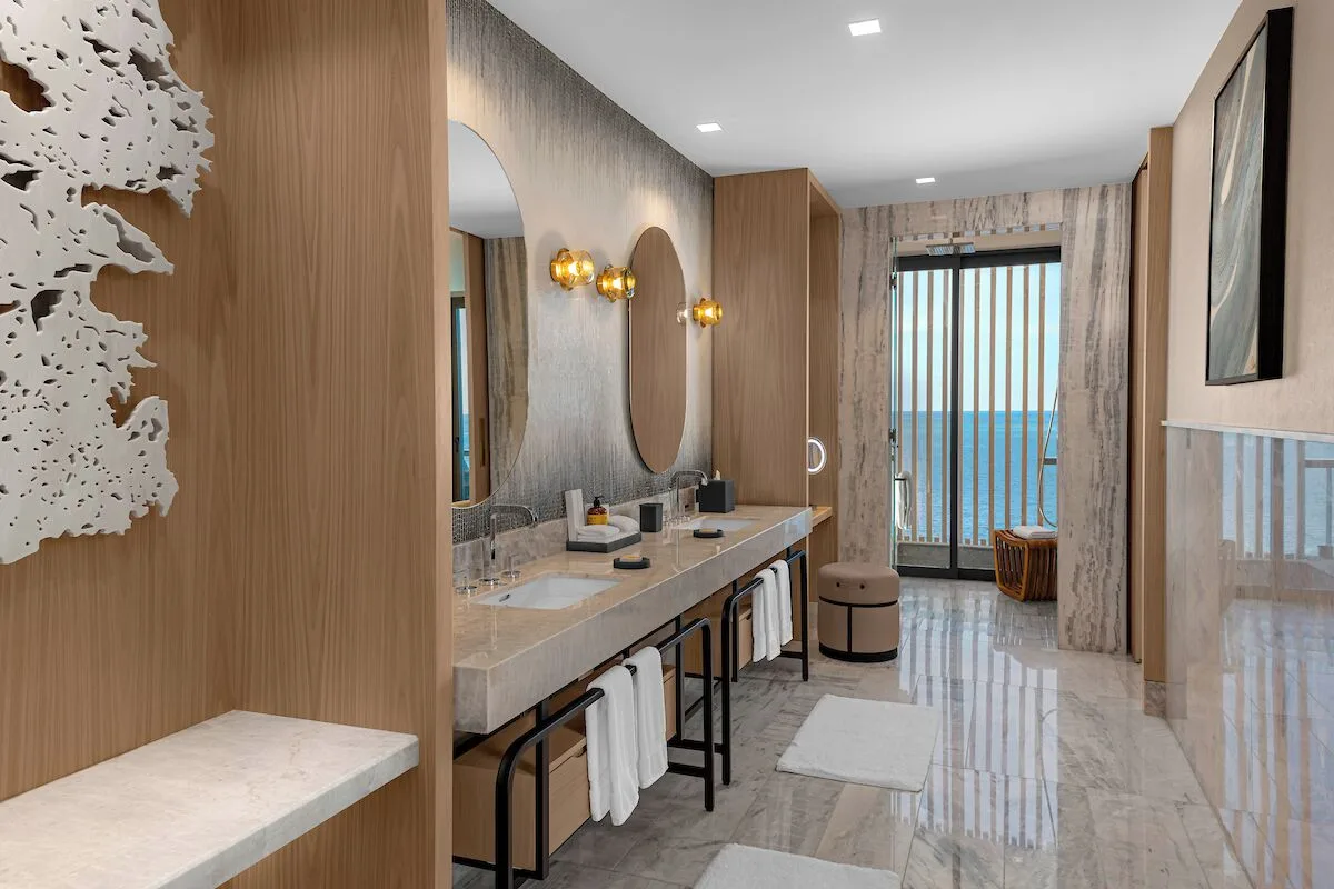 Suite bathroom with double vanity and ocean-facing doors at Waldorf Astoria Riviera Maya.
