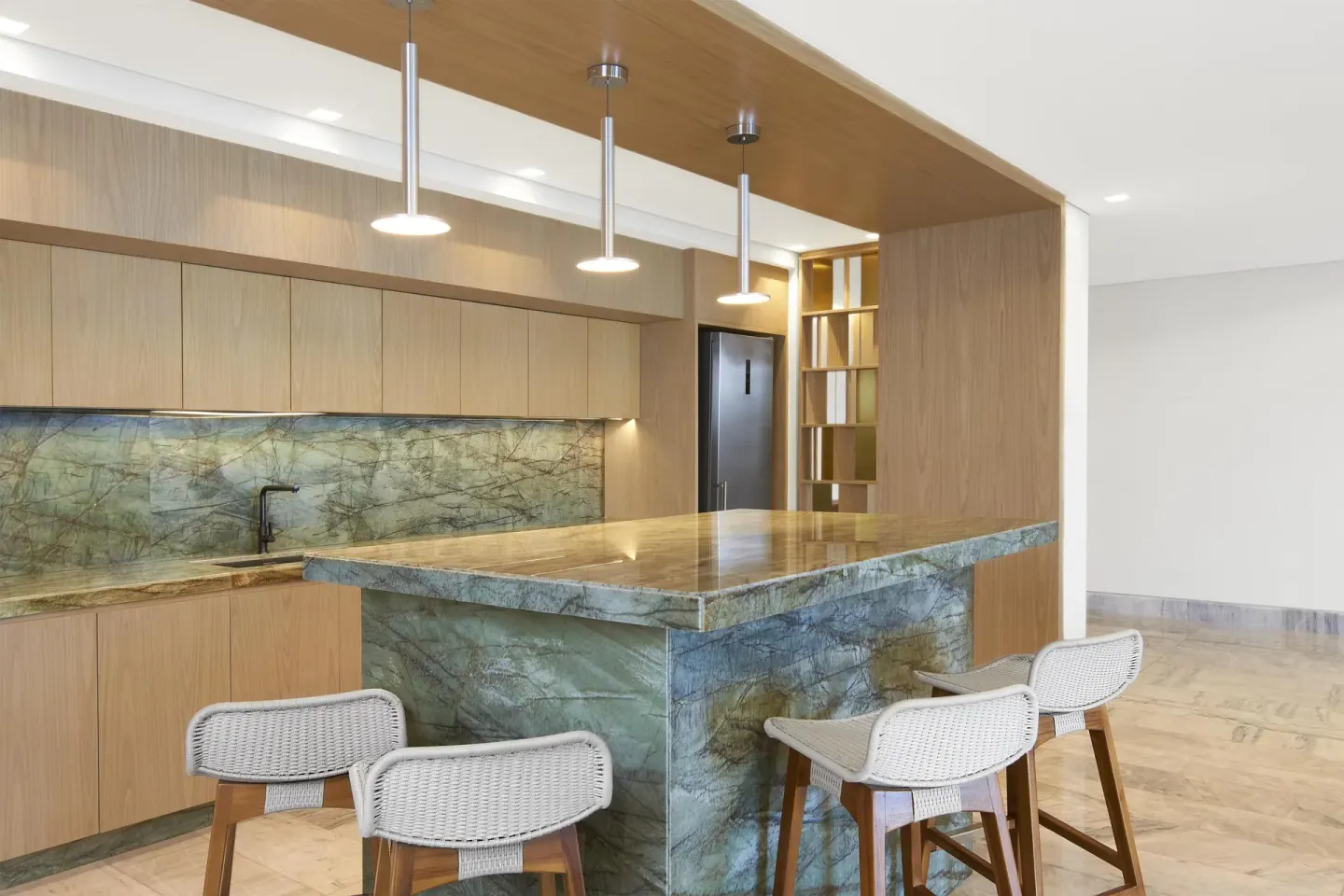 Suite kitchen island with stone counter and bar stools at Waldorf Astoria Riviera Maya.