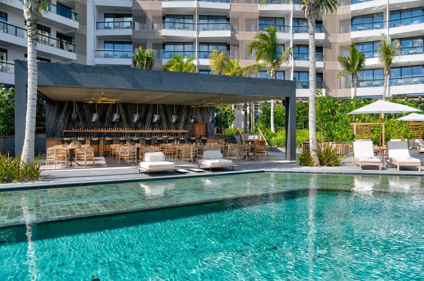 Poolside bar with seating beside the water at Waldorf Astoria Riviera Maya.