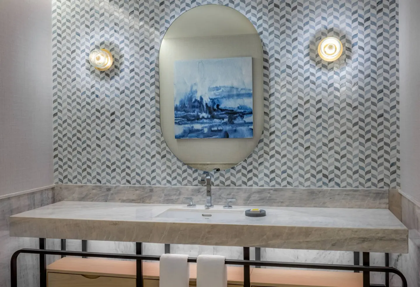 Bathroom sink with oval mirror in a guest room at Waldorf Astoria Riviera Maya.