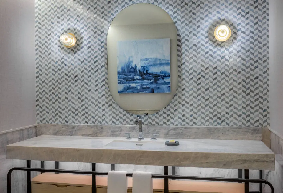 Bathroom sink with oval mirror in a guest room at Waldorf Astoria Riviera Maya.