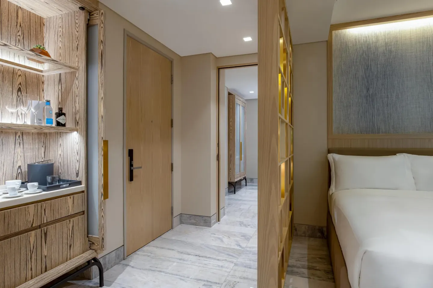 Entry area with refreshment cabinet and queen bed at Waldorf Astoria Riviera Maya.