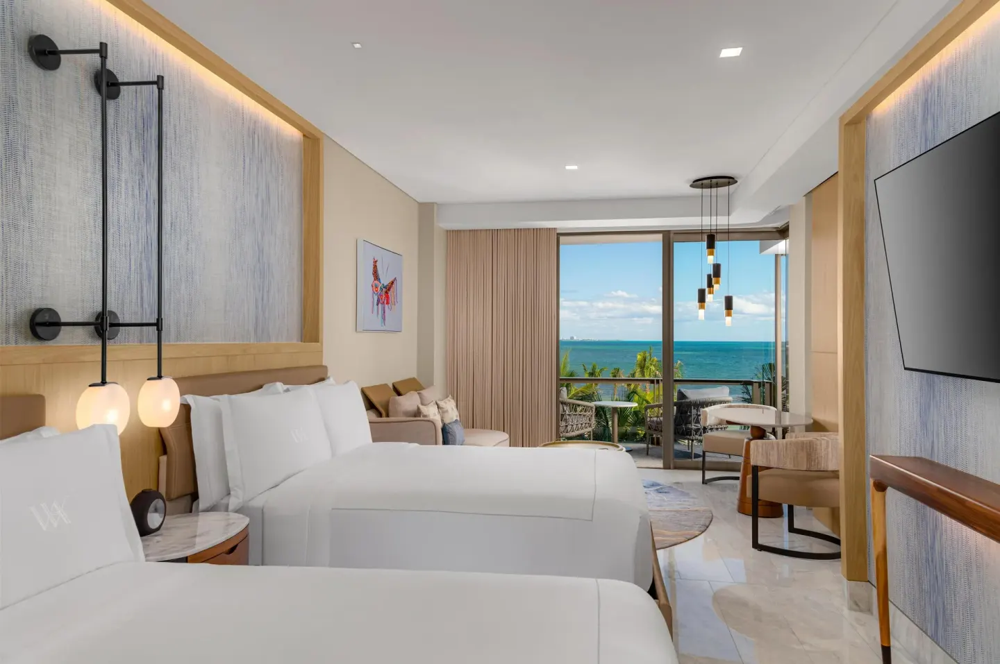 Oceanfront two-queen guest room with balcony view at Waldorf Astoria Riviera Maya.