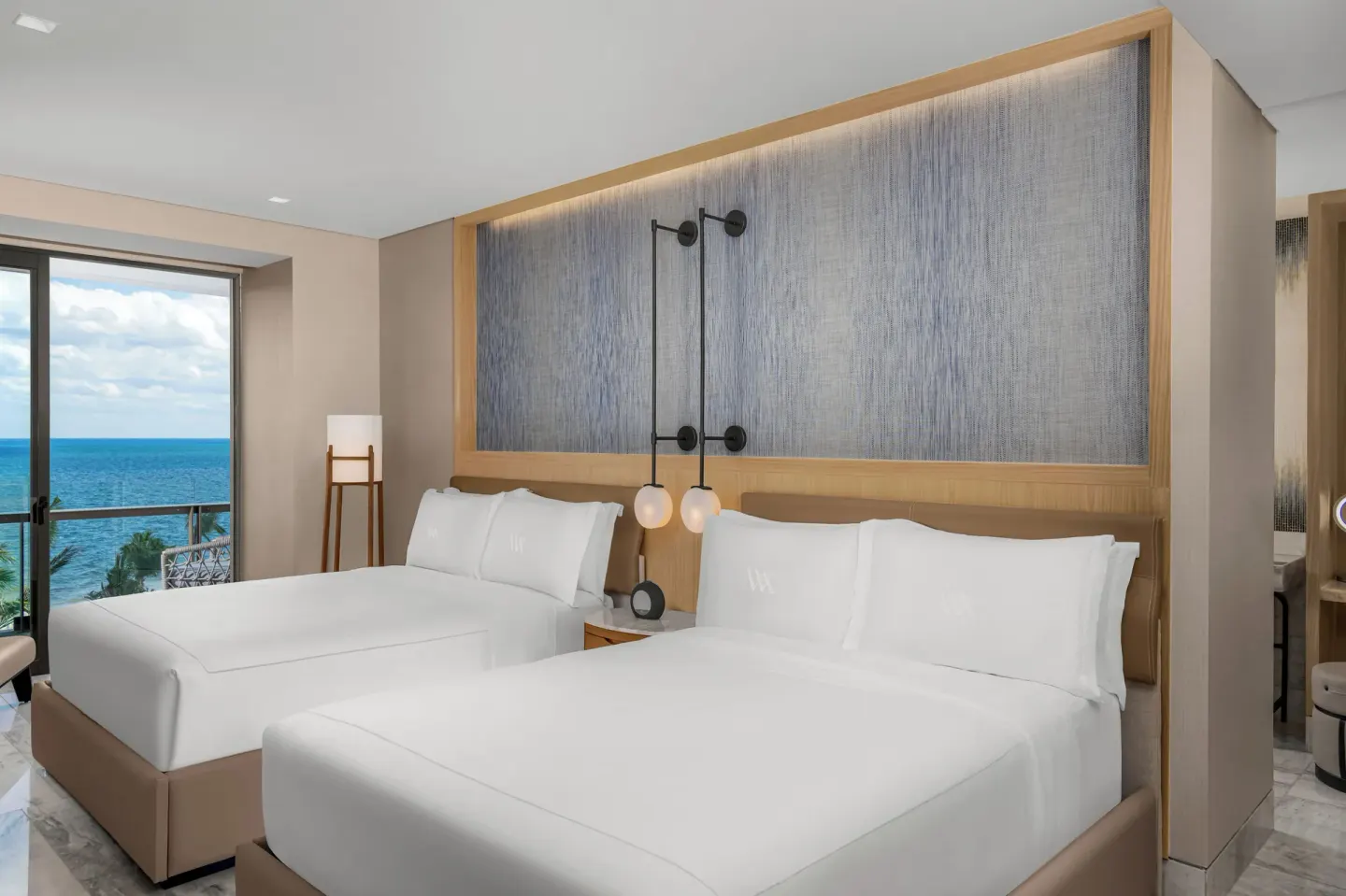 Two queen beds with ocean view window at Waldorf Astoria Riviera Maya.