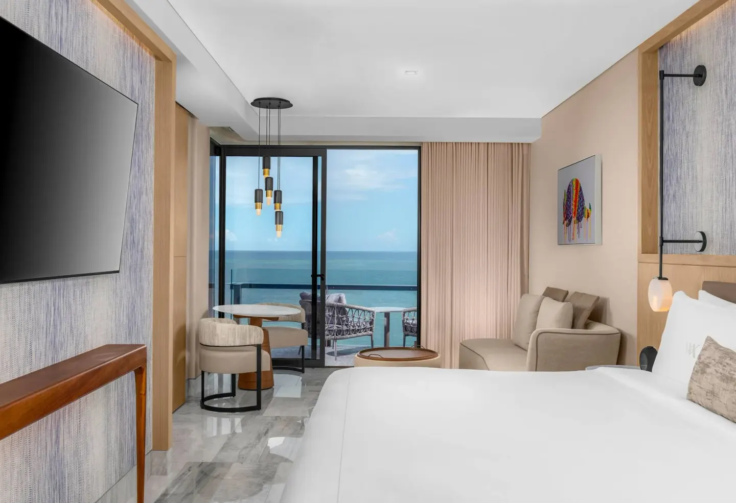 Deluxe Ocean Front guestroom with king bed and balcony view at Waldorf Astoria Riviera Maya.