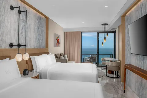 Ocean Front View guest room with two beds and balcony at Waldorf Astoria Riviera Maya.