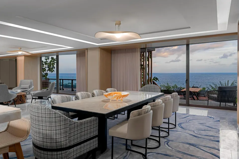 Presidential Suite dining table beside ocean-view windows at Waldorf Astoria Riviera Maya.