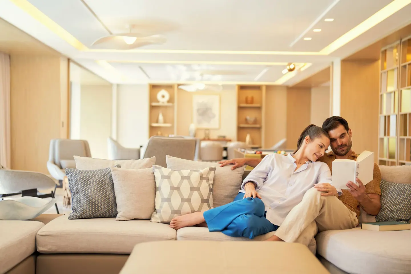 Guests read on the Presidential Suite sofa at Waldorf Astoria Riviera Maya.