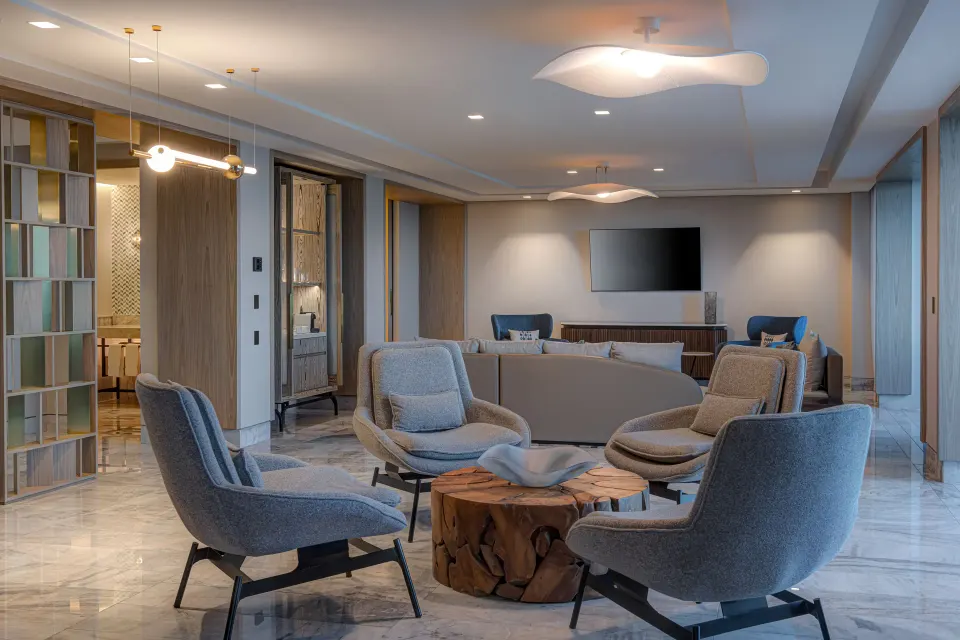 Presidential Suite lounge with armchairs and TV at Waldorf Astoria Riviera Maya.