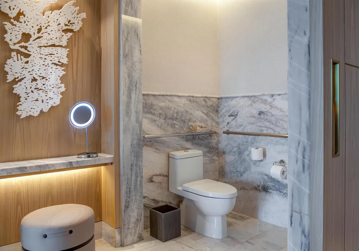 Accessible bathroom toilet area with marble walls at Waldorf Astoria Riviera Maya.
