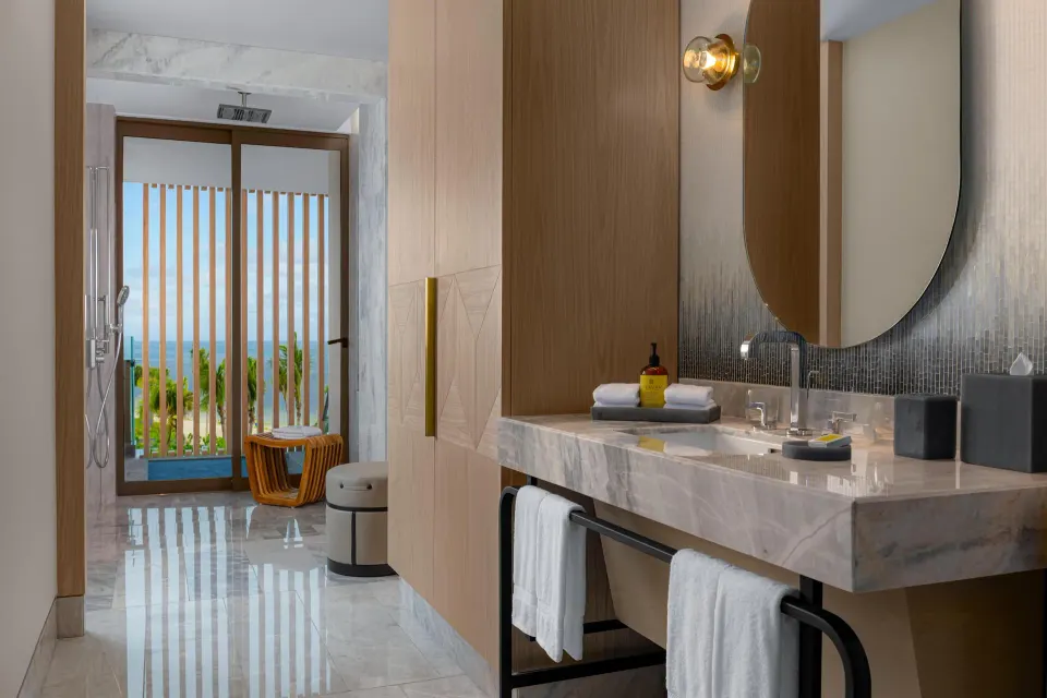 Accessible bathroom vanity with ocean-facing balcony beyond at Waldorf Astoria Riviera Maya.