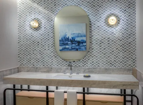 Marble accessible bathroom vanity with patterned wall at Waldorf Astoria Riviera Maya.