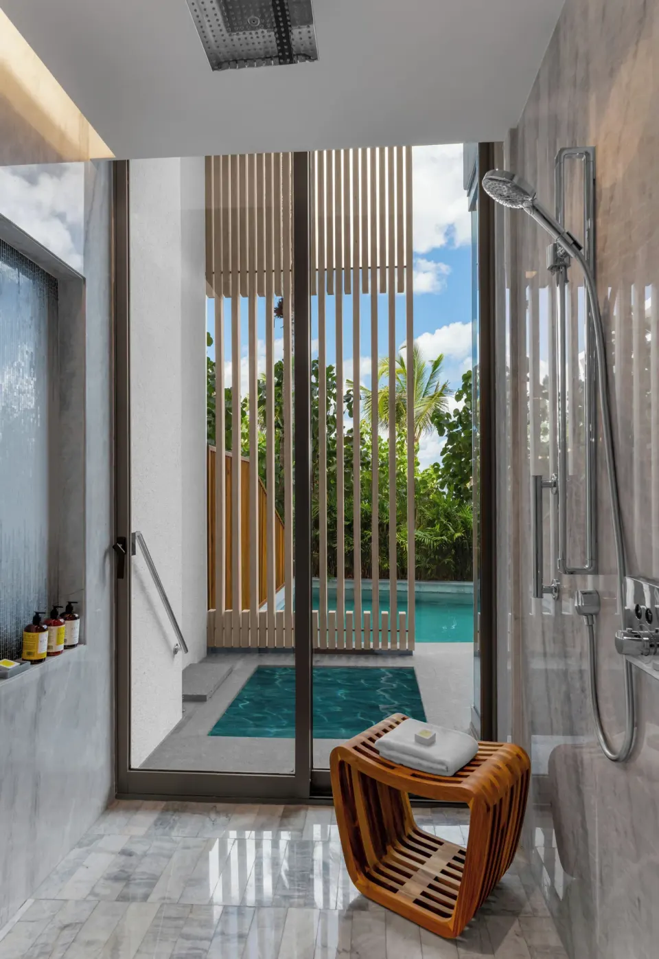 Marble bathroom with indoor shower and swim-up pool view at Waldorf Astoria Riviera Maya.