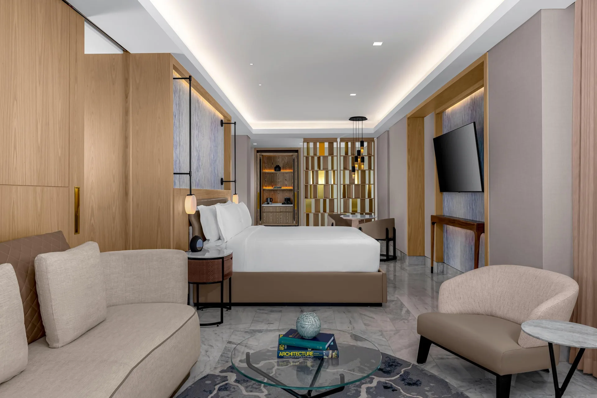 Corner ocean view suite bedroom with king bed and seating at Waldorf Astoria Riviera Maya.