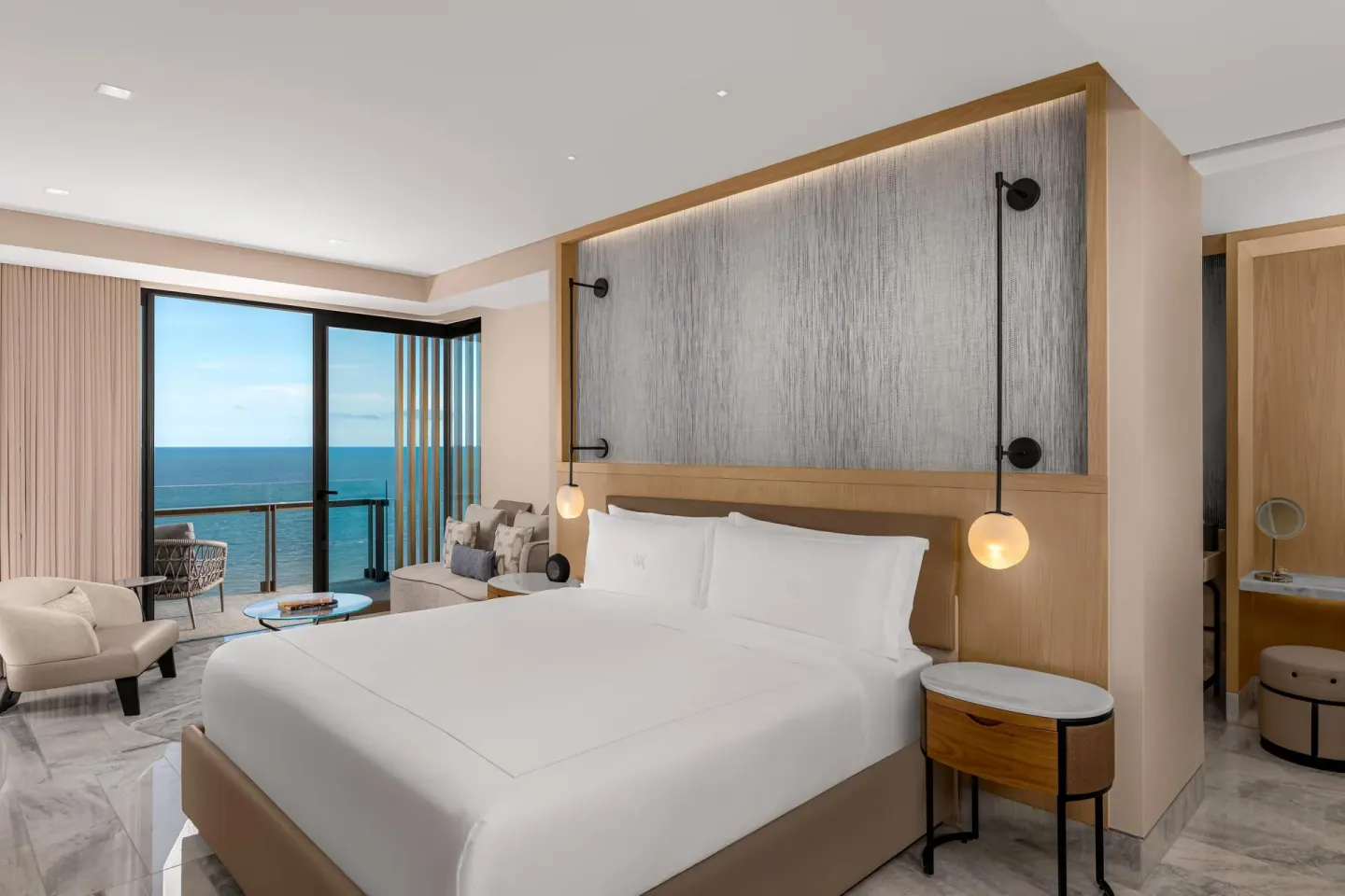 Oceanfront suite king bed and balcony with sea view at Waldorf Astoria Riviera Maya.