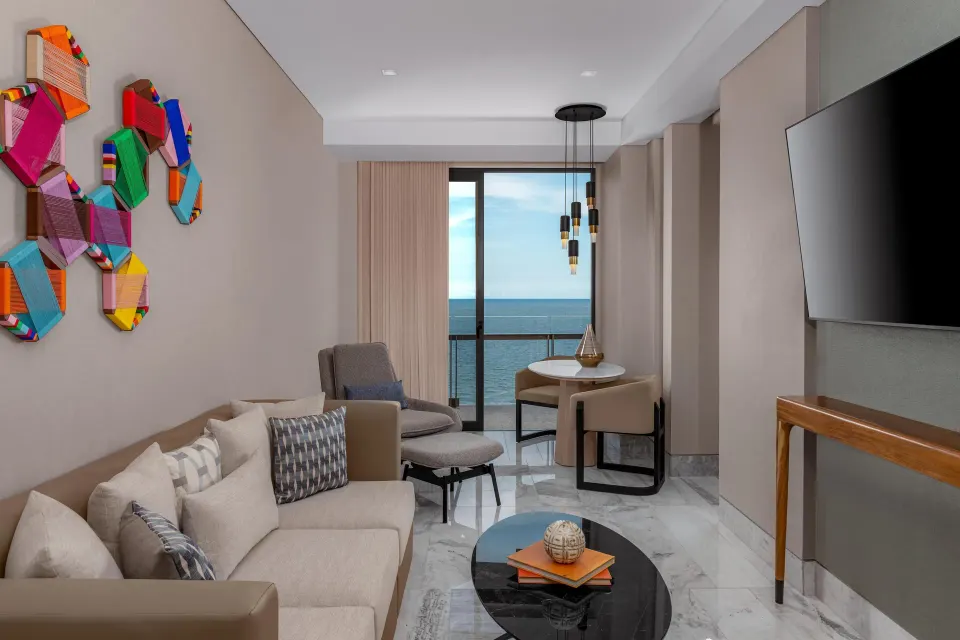 Oceanfront suite living area with balcony sea view at Waldorf Astoria Riviera Maya.