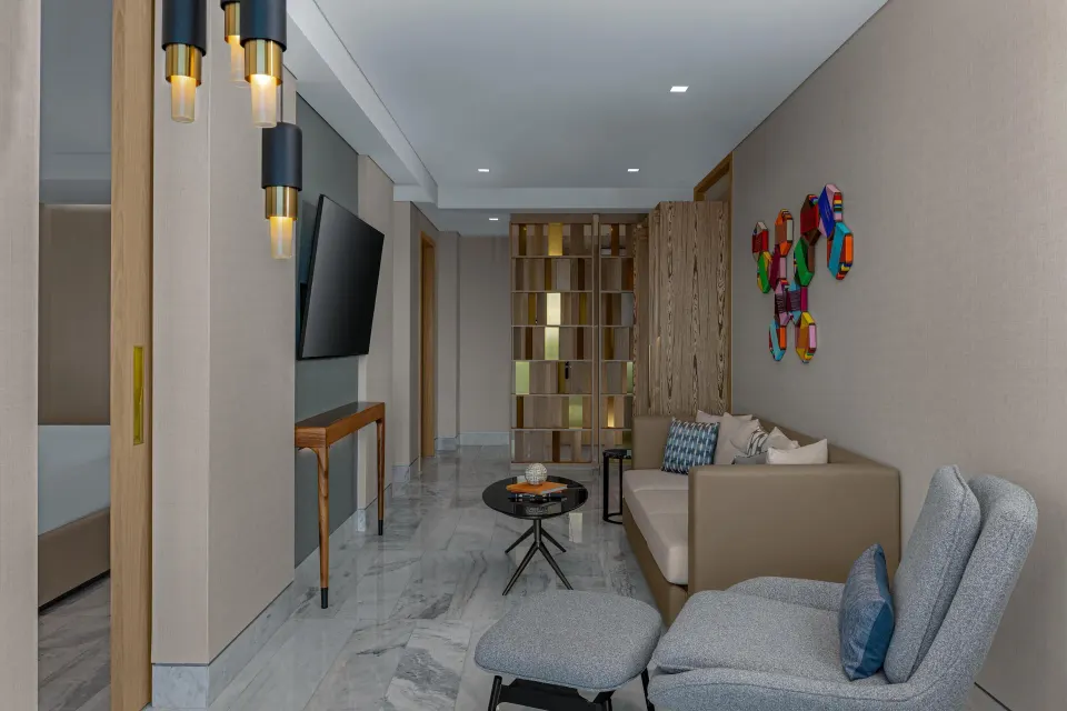 Oceanfront suite sitting area with sofa and lounge chair at Waldorf Astoria Riviera Maya.