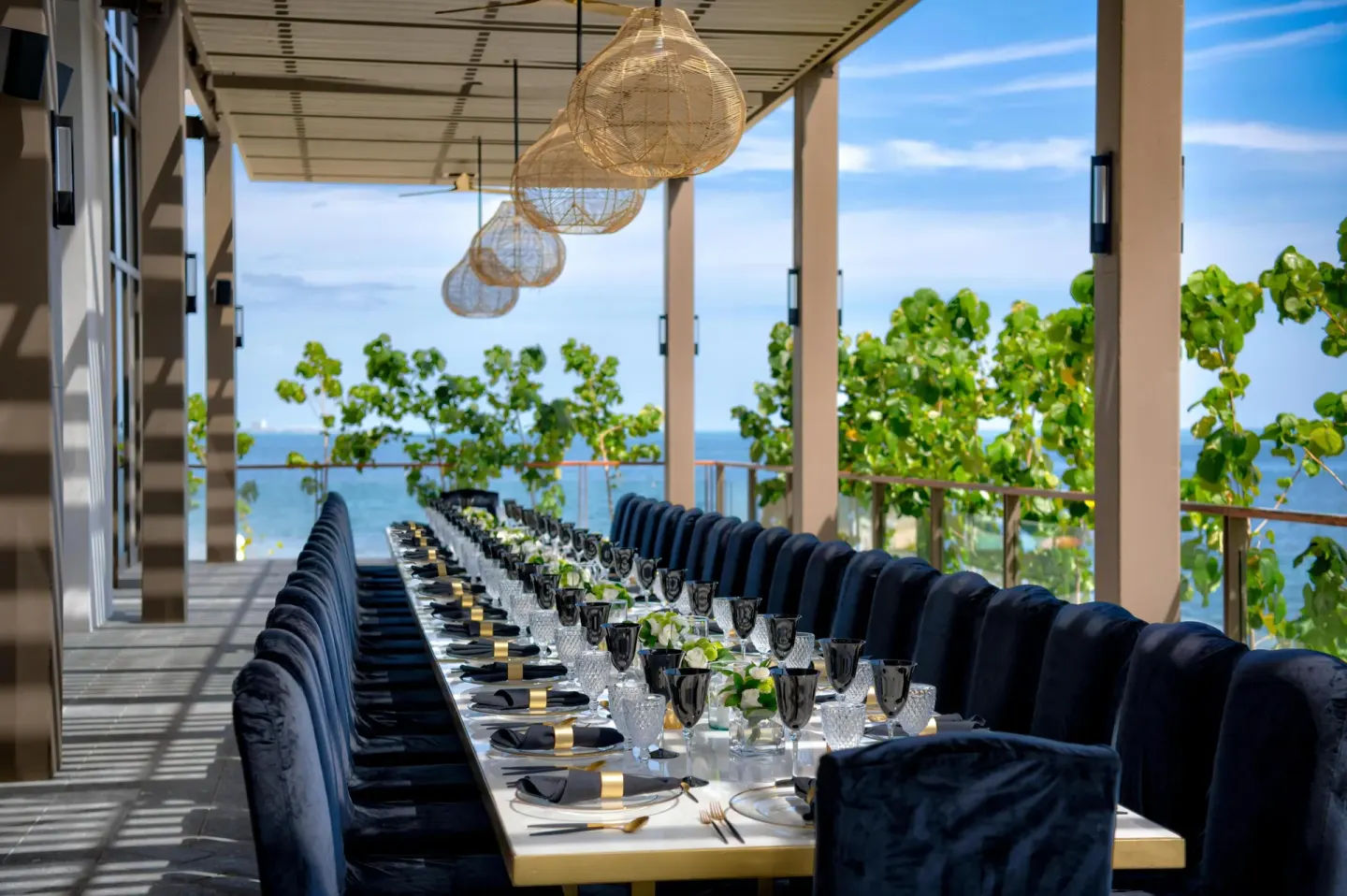 Long oceanfront event table set on a terrace at Waldorf Astoria Riviera Maya.