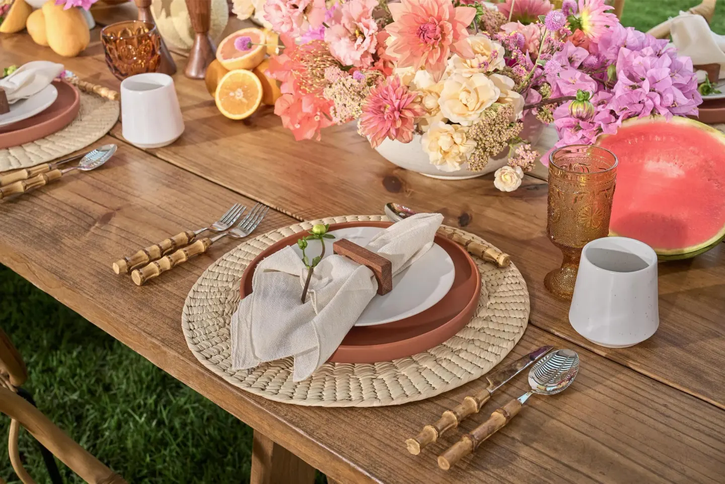 Outdoor event table with flowers, place settings and fruit at Waldorf Astoria Riviera Maya.
