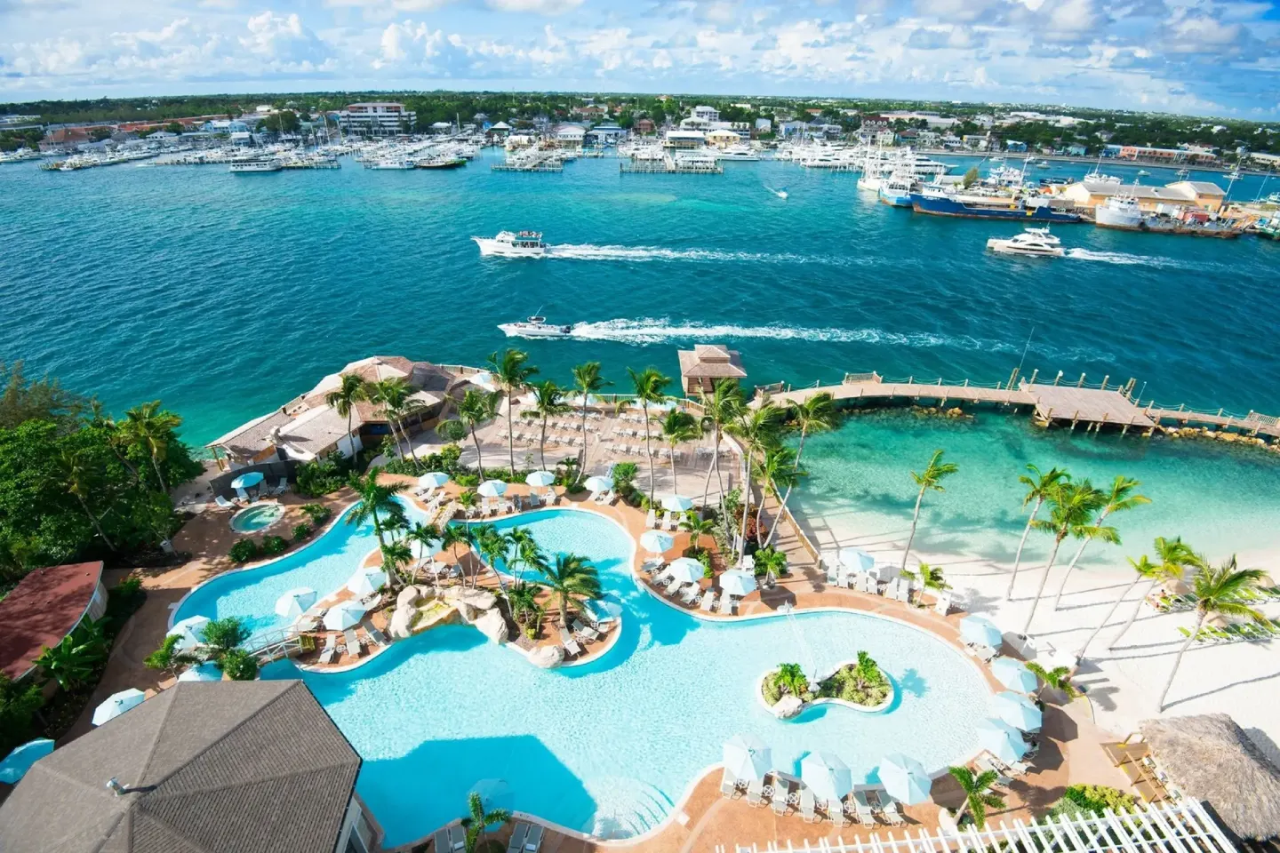 Aerial view of the pool, beach cove and marina beside Warwick Paradise Island.