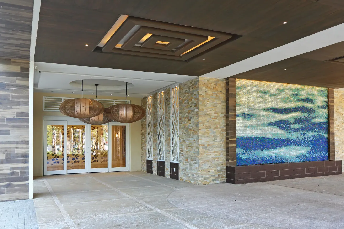 The covered entrance at Warwick Paradise Island features pendant lights and a mosaic wall.