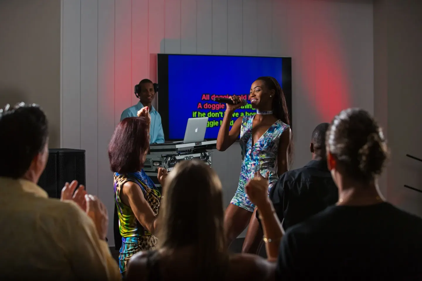 A guest sings karaoke while an audience watches at Warwick Paradise Island.