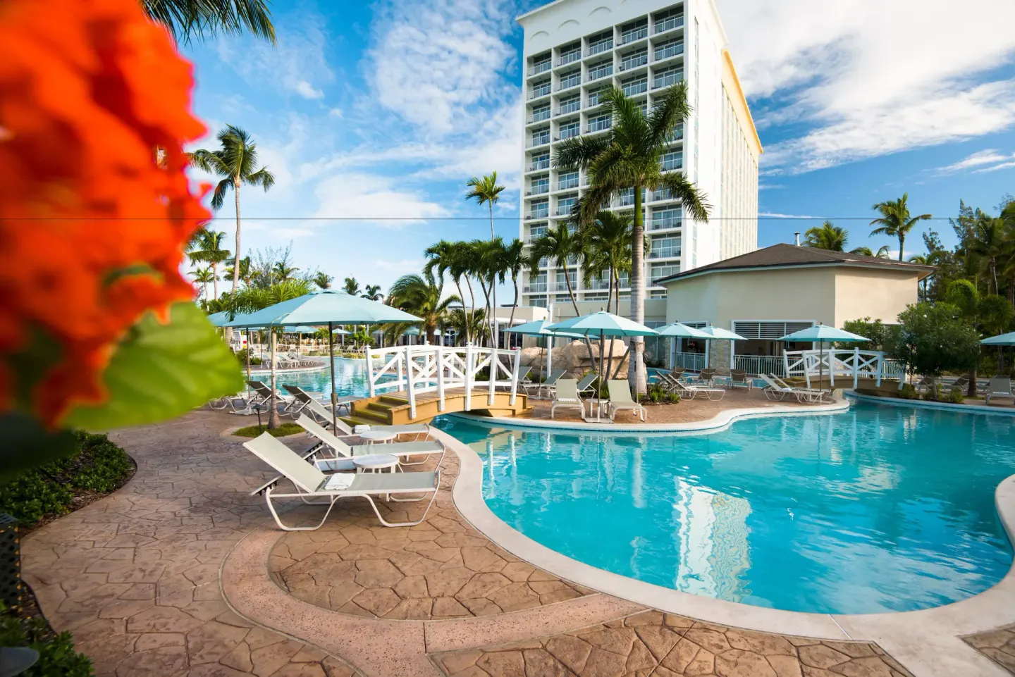 Resort pool, loungers, umbrellas and tower building at Warwick Paradise Island.