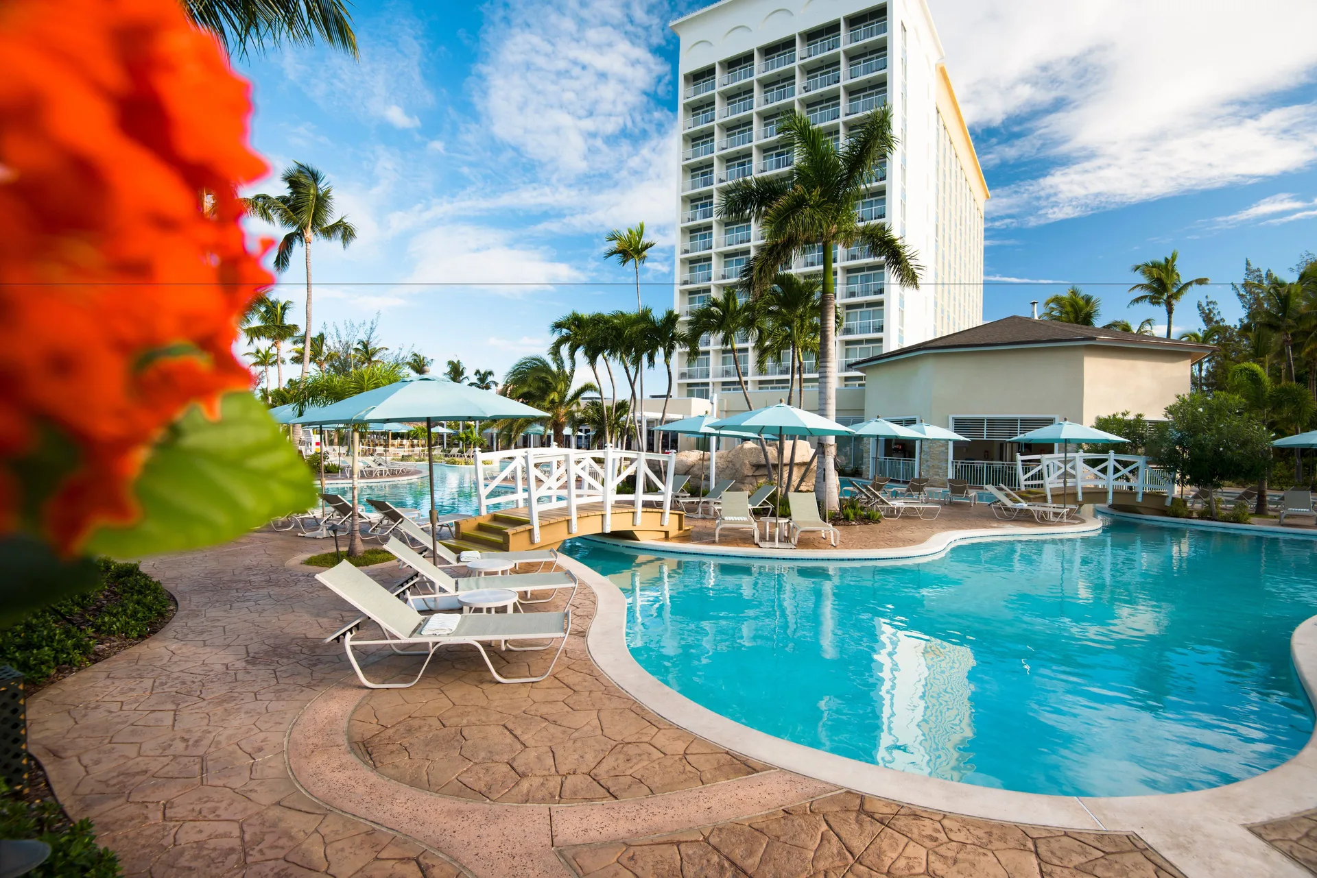 Resort pool, loungers, umbrellas and tower building at Warwick Paradise Island.