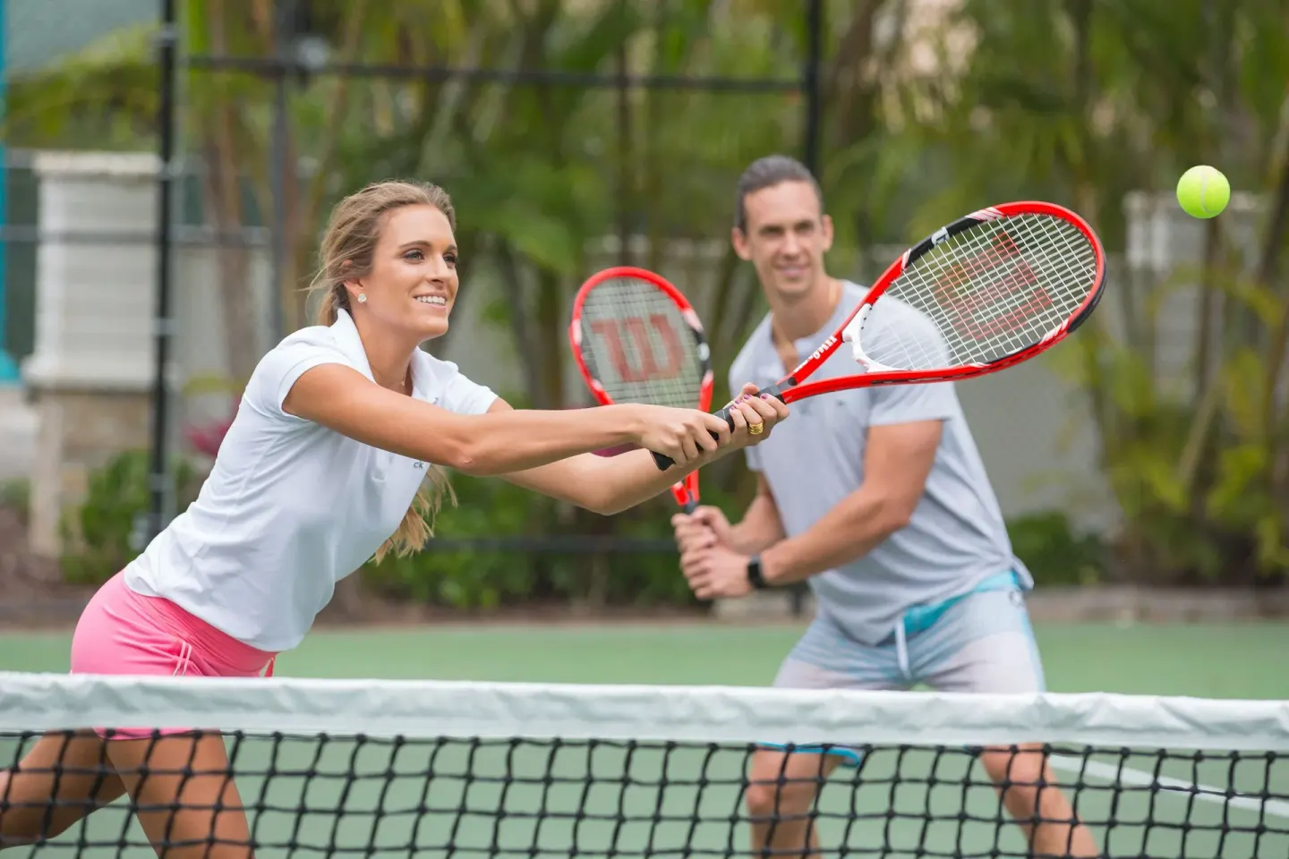 Guests play tennis on an outdoor court at Warwick Paradise Island.