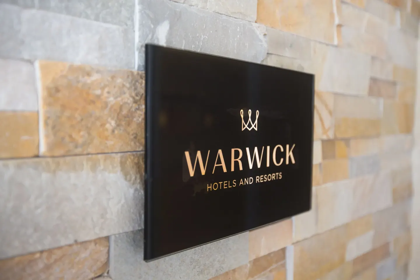 Warwick wall sign mounted on stone tile at Warwick Paradise Island.