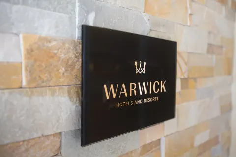 Warwick wall sign mounted on stone tile at Warwick Paradise Island.