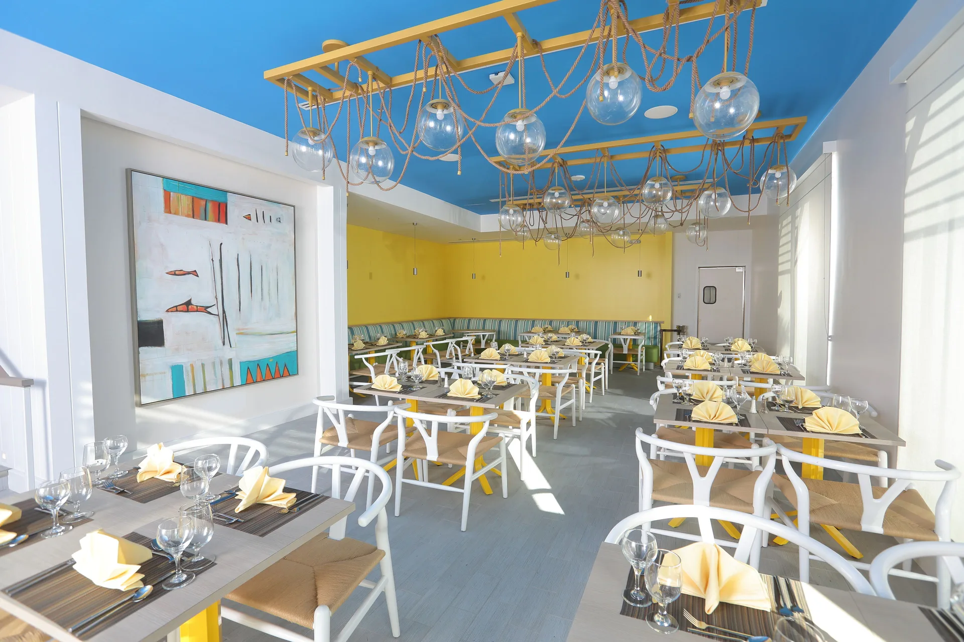 Bright dining room with set tables and blue ceiling at Warwick Paradise Island.