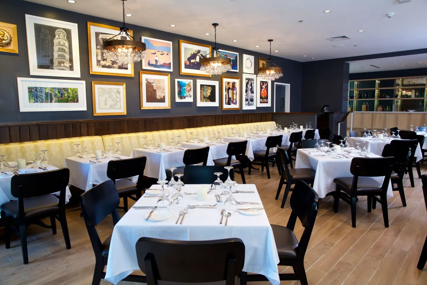 Formal dining room with framed artwork and white tablecloths at Warwick Paradise Island.