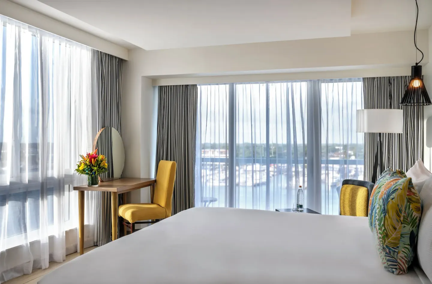 Harbour Premium Balcony room with king bed, desk, and waterfront windows at Warwick Paradise Island.