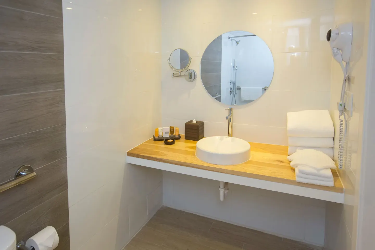 Island View guest room bathroom vanity with round mirror at Warwick Paradise Island.