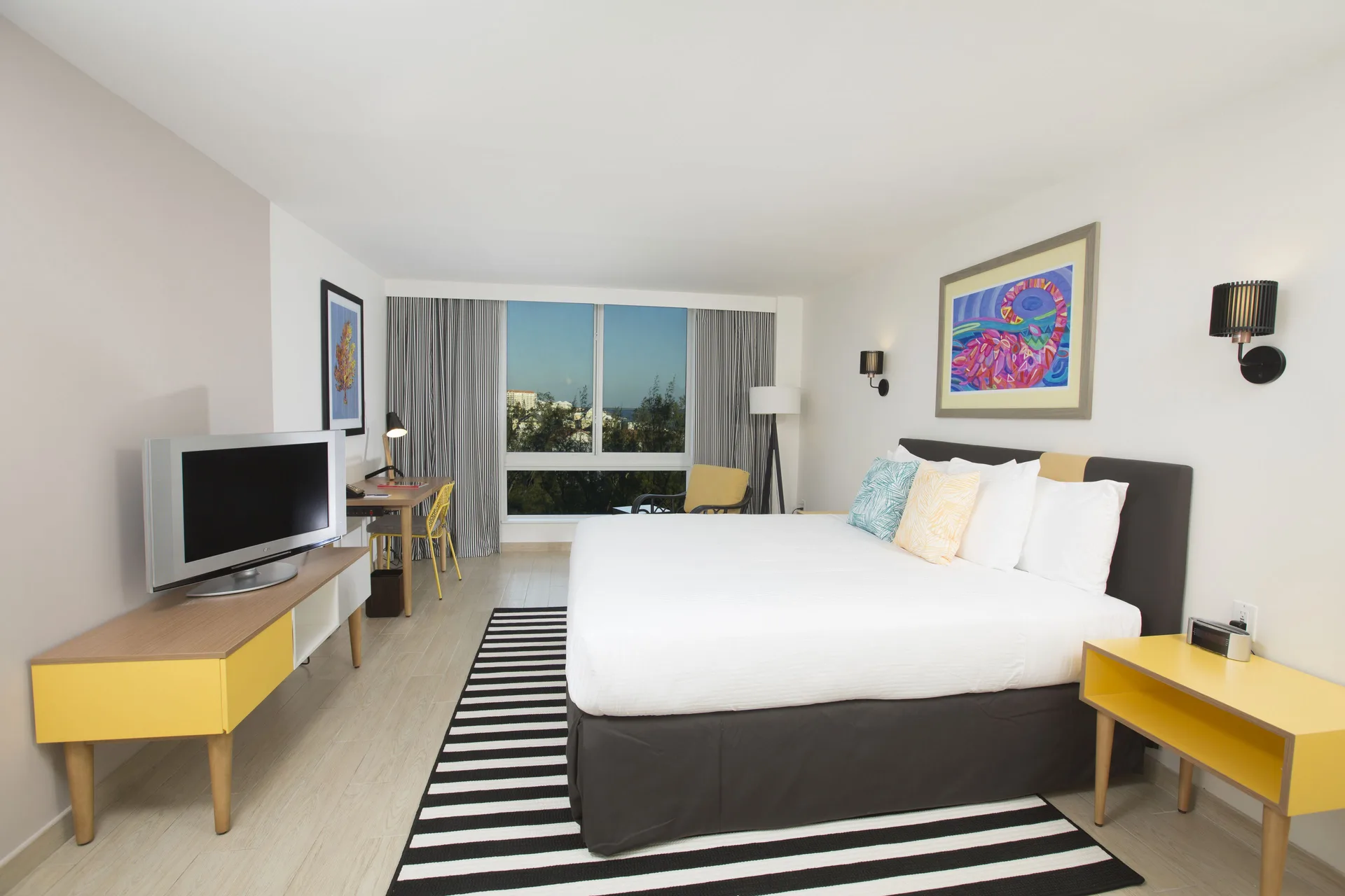 Island View room with king bed, TV, desk, and window at Warwick Paradise Island.